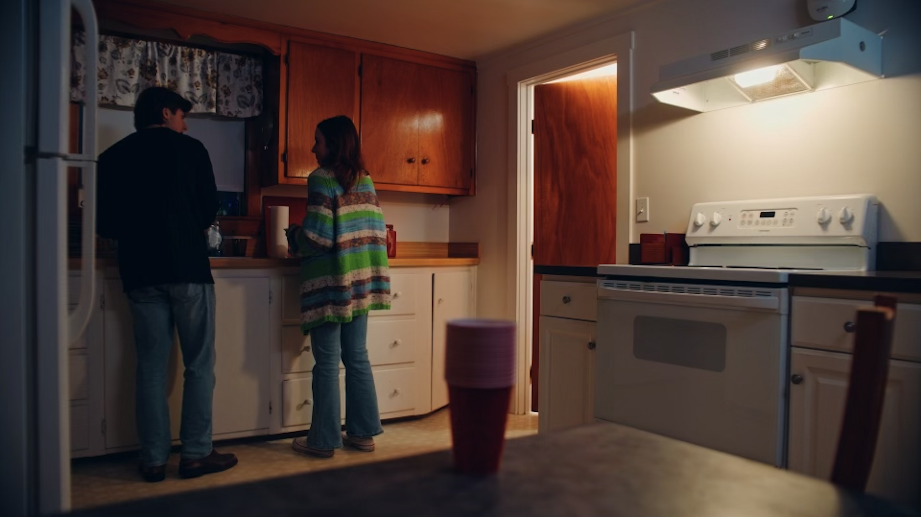 A man and woman talk in the kitchen