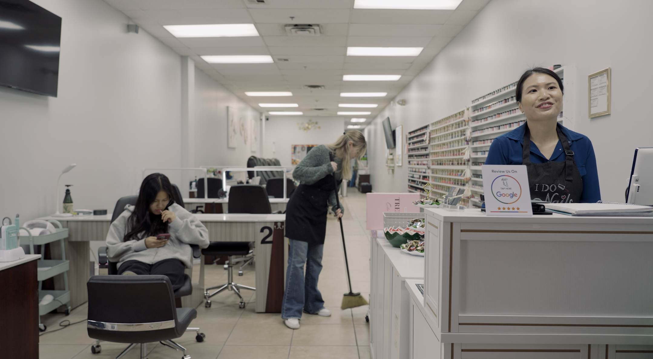 A woman and two girls work in a nail salon